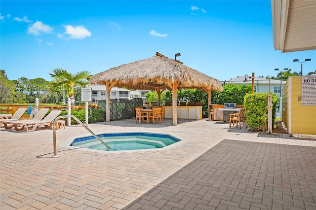 view of pool featuring a community hot tub, a patio, an outdoor bar, and a gazebo