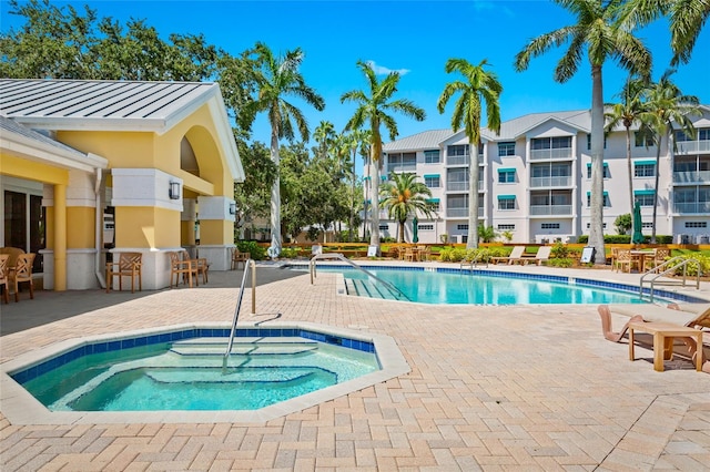 view of pool with a patio area and a hot tub