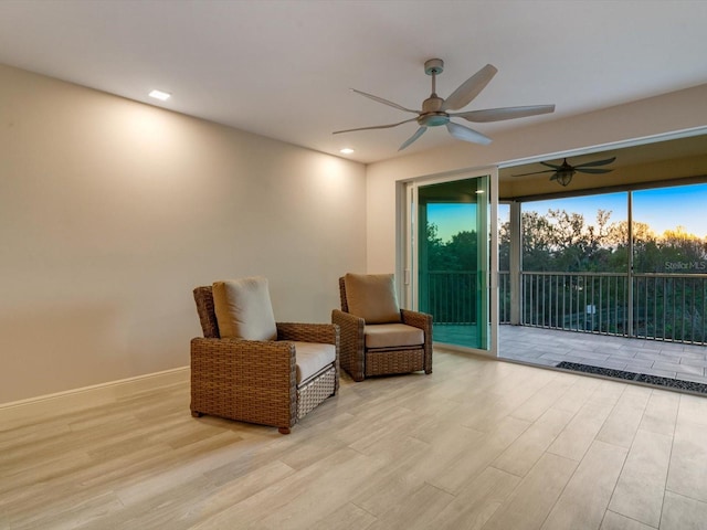 living area featuring light hardwood / wood-style flooring and ceiling fan