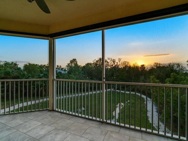 unfurnished sunroom featuring ceiling fan