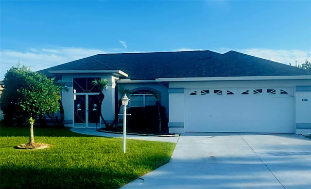 single story home with a front yard and a garage