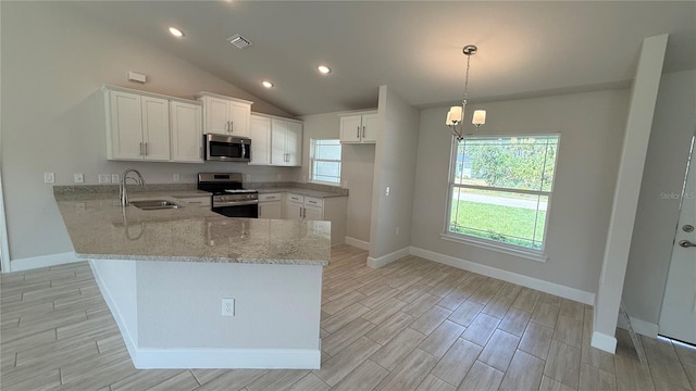 kitchen with a sink, light stone counters, baseboards, a peninsula, and stainless steel appliances