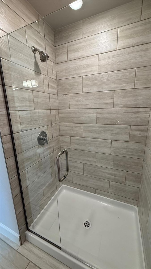 bathroom featuring baseboards and a shower stall