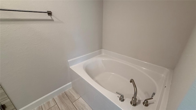 bathroom with baseboards and a garden tub