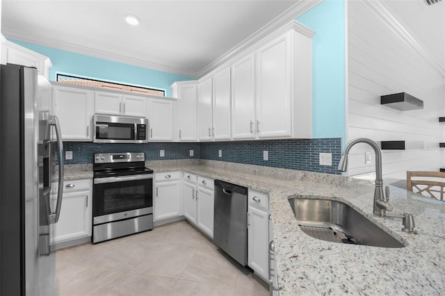 kitchen with light stone counters, sink, white cabinetry, stainless steel appliances, and crown molding