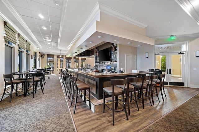 kitchen with a kitchen breakfast bar, hardwood / wood-style flooring, french doors, and crown molding