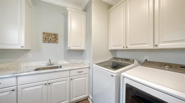 laundry area with crown molding, separate washer and dryer, sink, and cabinets