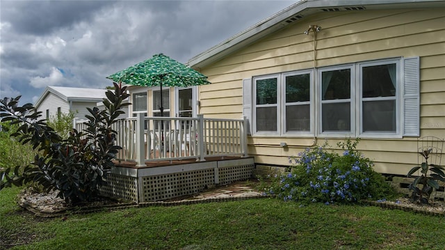 view of home's exterior featuring a wooden deck and a yard