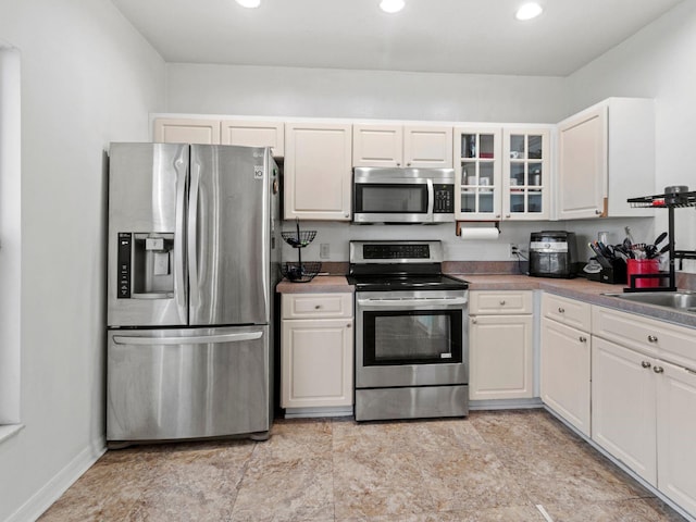 kitchen featuring appliances with stainless steel finishes, sink, and white cabinetry