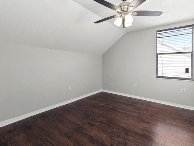 additional living space with a textured ceiling, vaulted ceiling, dark hardwood / wood-style floors, and ceiling fan