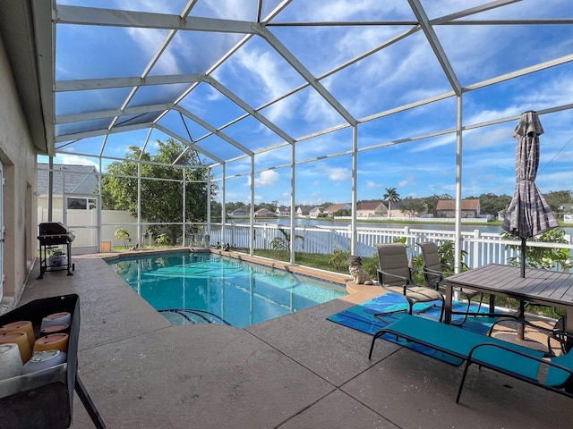 view of pool with grilling area, a water view, a lanai, and a patio area