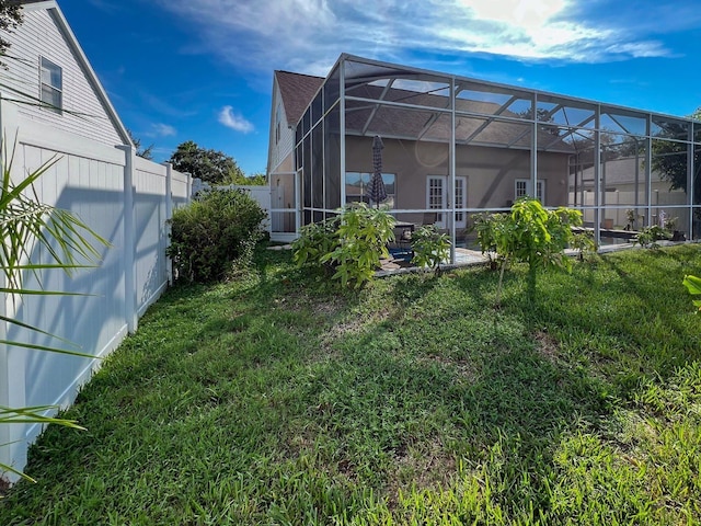 view of yard with glass enclosure and a patio area