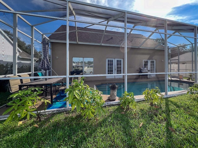 back of house featuring a patio, glass enclosure, and french doors