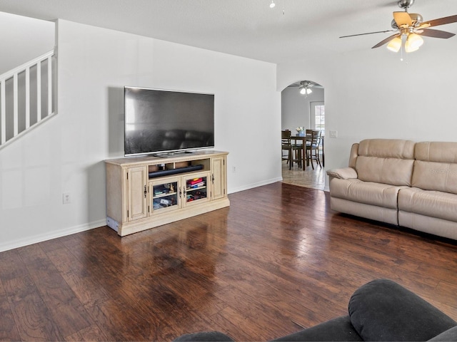 7209 49th Pl E, Palmetto, FL 34221 - living room with dark wood-type flooring, arched walkways, a ceiling fan, and stairs