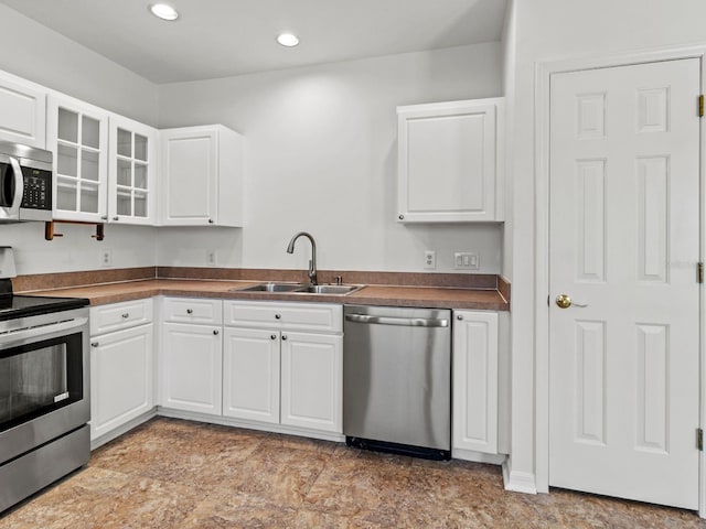 7209 49th Pl E, Palmetto, FL 34221 - kitchen with white cabinets, a sink, dark countertops, glass insert cabinets, and appliances with stainless steel finishes