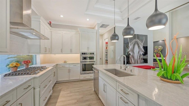 kitchen with crown molding, wall chimney exhaust hood, visible vents, a sink, and stainless steel appliances