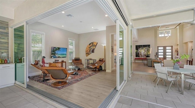 living area featuring visible vents, baseboards, french doors, and a healthy amount of sunlight