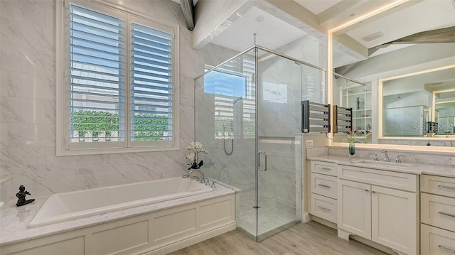 bathroom featuring a shower stall, vanity, a garden tub, and wood finished floors