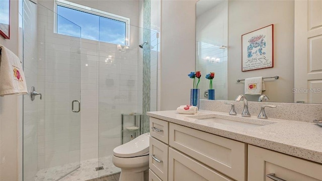 bathroom featuring toilet, a shower stall, and vanity