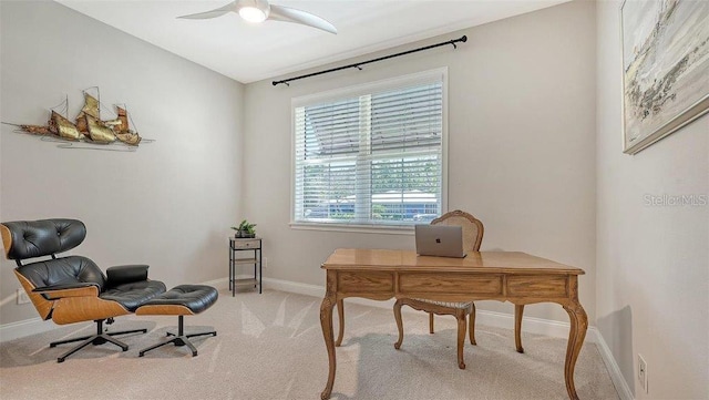 home office with light carpet, ceiling fan, and baseboards