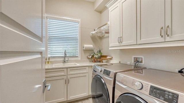 laundry room with a sink, cabinet space, and washer and dryer