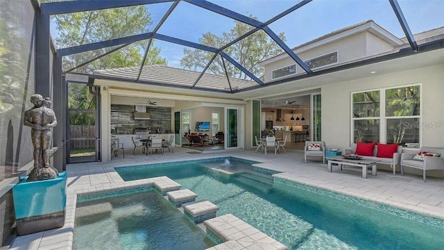 exterior space featuring an outdoor hangout area, a patio, an in ground hot tub, glass enclosure, and ceiling fan