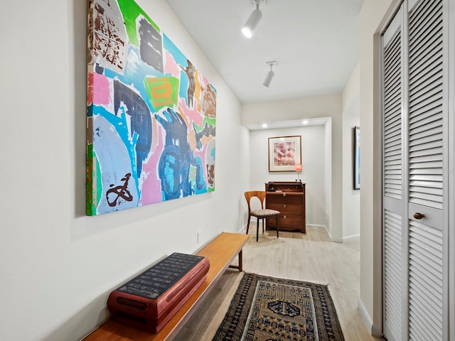 hall with track lighting and hardwood / wood-style flooring