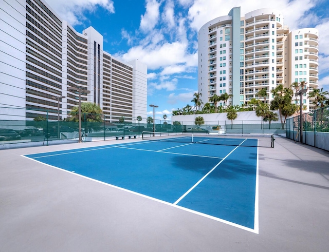 view of tennis court with basketball hoop