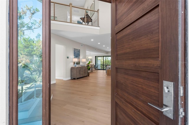 foyer entrance with a high ceiling and light wood-type flooring