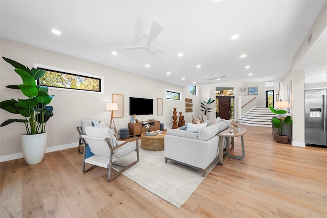 living room featuring light hardwood / wood-style floors and ceiling fan