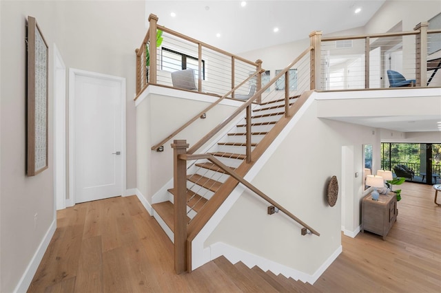 stairs with hardwood / wood-style flooring and vaulted ceiling