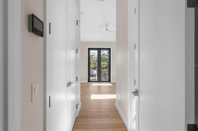 hall with light hardwood / wood-style flooring and french doors