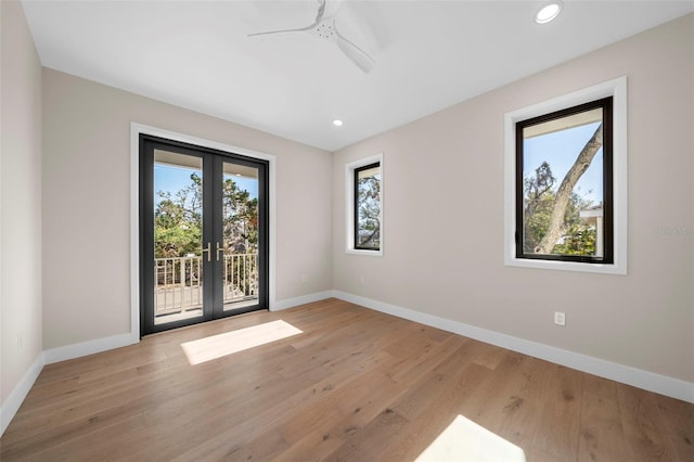 empty room with ceiling fan, light hardwood / wood-style floors, and french doors