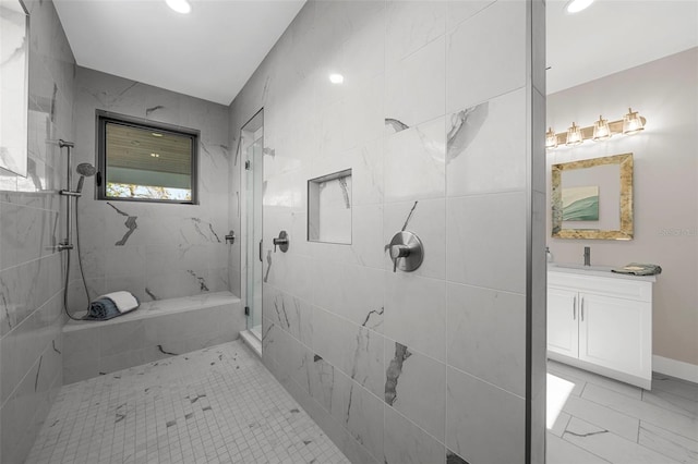 bathroom featuring a tile shower and vanity