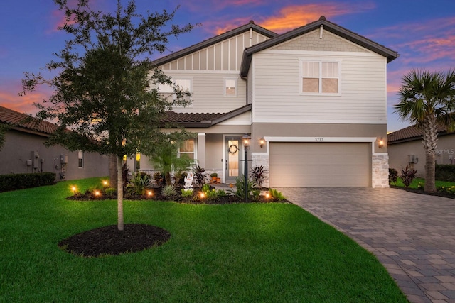 craftsman inspired home with a yard and a garage