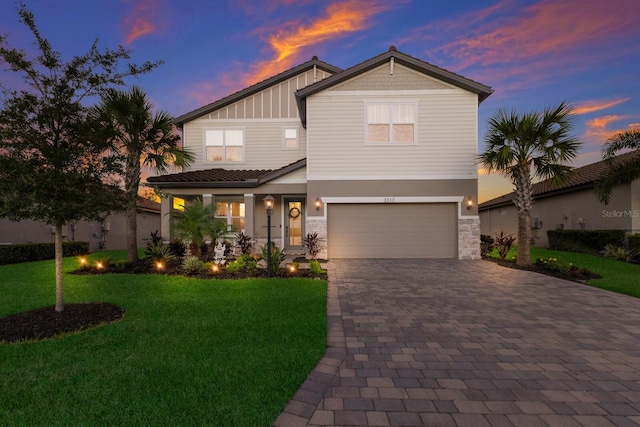 craftsman house featuring a garage and a lawn