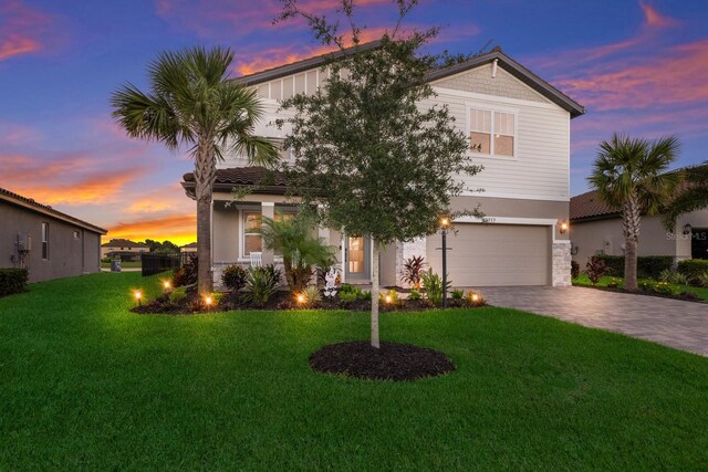 view of front of property with a garage and a lawn