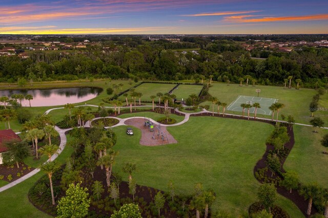 aerial view at dusk featuring a water view