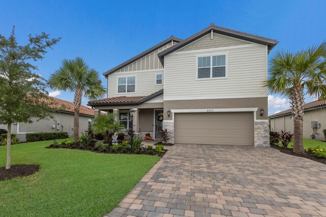 craftsman inspired home with a garage and a front lawn