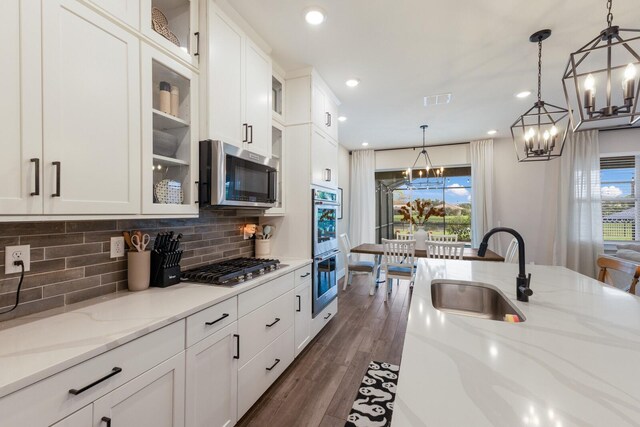 kitchen with stainless steel appliances, dark wood-type flooring, sink, and white cabinetry