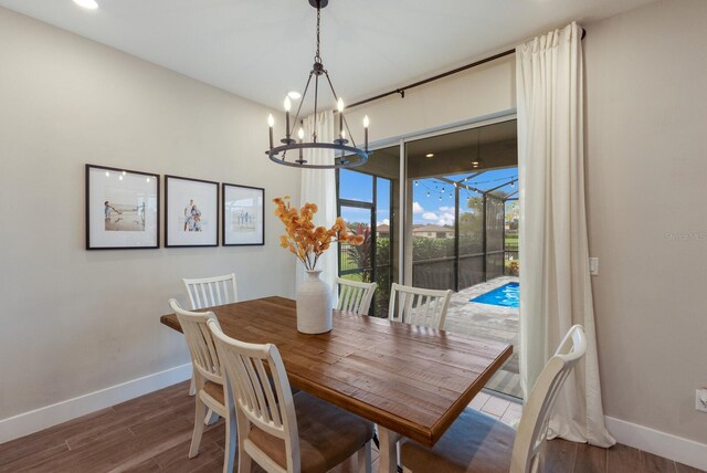 dining room with hardwood / wood-style floors and a chandelier