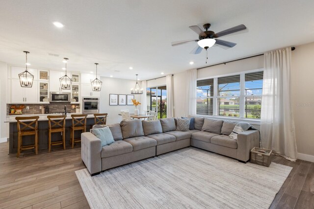 living room with light wood-type flooring and ceiling fan