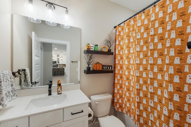 bathroom featuring vanity, toilet, and curtained shower