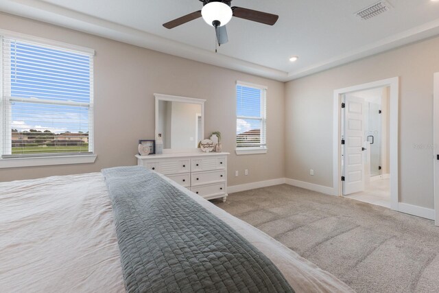 carpeted bedroom featuring ceiling fan and multiple windows