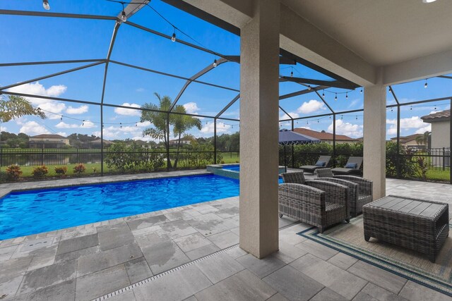 view of swimming pool featuring glass enclosure and a patio area