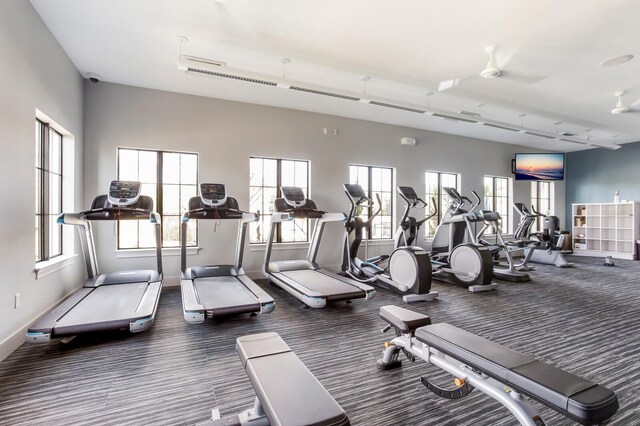 exercise room featuring dark carpet