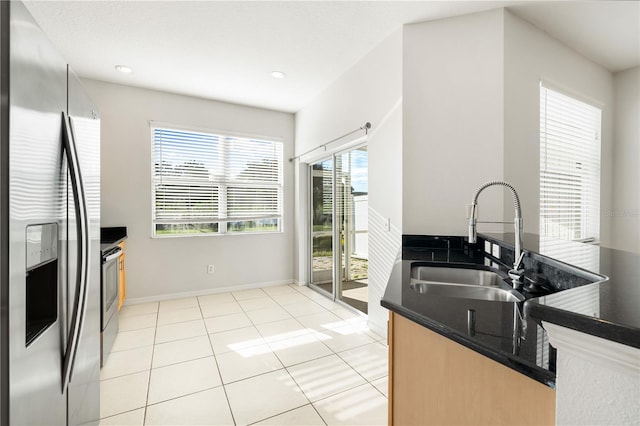 kitchen with stainless steel fridge with ice dispenser, sink, a wealth of natural light, and range