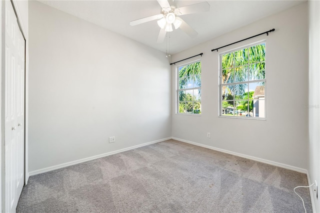 carpeted empty room featuring ceiling fan