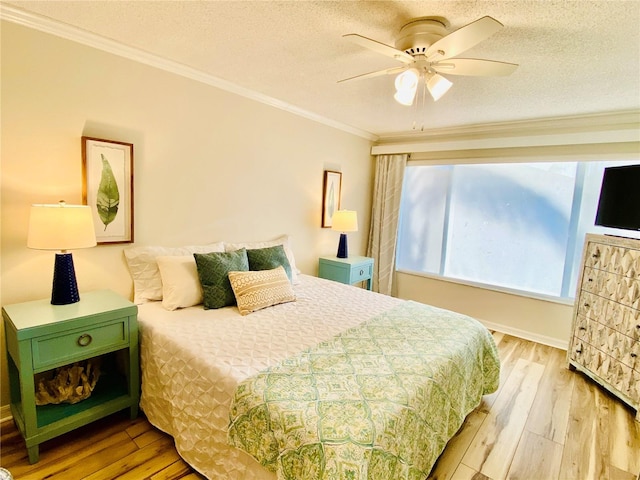 bedroom with a textured ceiling, light wood-type flooring, ceiling fan, and crown molding