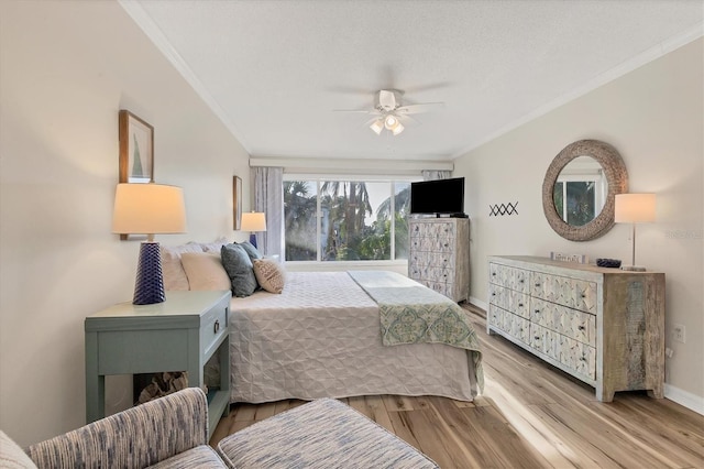 bedroom with light wood-type flooring, a textured ceiling, ceiling fan, and ornamental molding